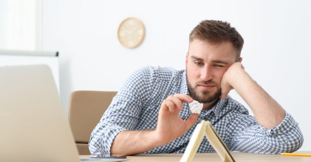 prokrastynacja czym jest to zjawisko mężczyzna przy biurku